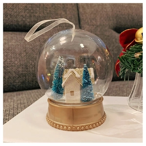 Detail of Christmas snow globe with a snow-covered cottage and festive trees