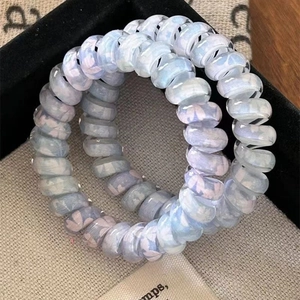 Blue spiral telephone wire hair ties with clover floral print in a black display box