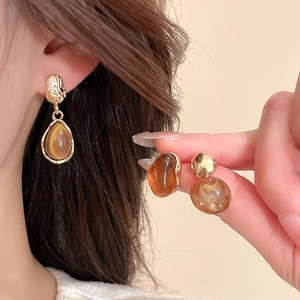 Vue détaillée de boucles d'oreilles rétro en résine ambrée et base dorée