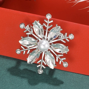 Macro detail of snowflake brooch with marquise crystals and faux pearl centerpiece