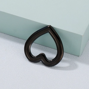 Black hollow heart-shaped metal pendant charm with high gloss finish on minimalist background