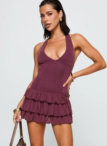 Detail of the dark purple halter neck dress featuring layered ruffle cake skirt design