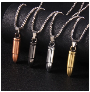 Polished bullet pendants in bronze, grey, silver, and gold on textured background