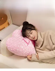 Detailed view of soft pink heart-shaped plush pillow with embroidered letter texture