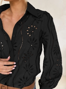 Detail of elegant hollow-out floral embroidery on a black button-down cardigan blouse