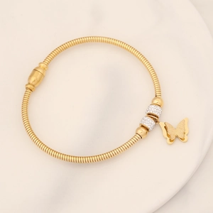 Close-up of golden butterfly charm bracelet with sparkling rhinestones and snake chain