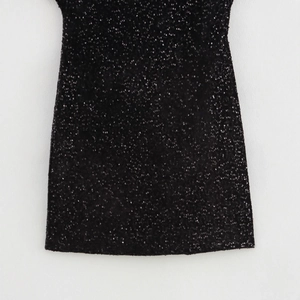 Abito stringato alla moda con paillettes nere e trama fitta su sfondo bianco