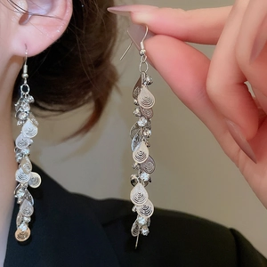 Detailed view of silver drop fringe earrings with sequins and rhinestones on model