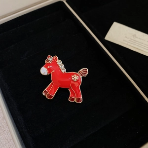 Detail of red enamel horse brooch with sparkling rhinestones in a luxury jewelry box