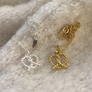 925 sterling silver pretzel heart pendant necklace in gold and silver finish on fabric