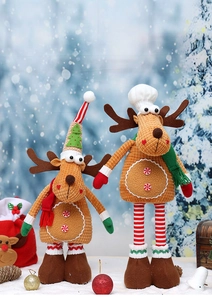 Detail of two Christmas reindeer plush dolls with knitted hats on a snow background
