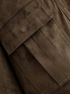 Detailed macro view of brown faux suede bomber jacket with flap pocket and stitching