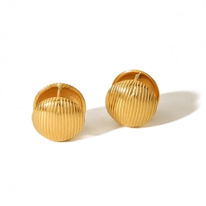 Macro detail of golden stainless steel hoop earrings with textured vertical shell stripes