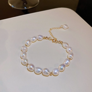 Detailed macro shot of baroque pearls with golden beads and adjustable lobster clasp