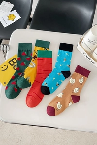 Flat lay of five colorful cotton socks featuring fruit and animal jacquard patterns