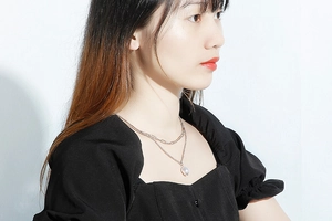 Close-up of double layer titanium steel necklace with baroque pearl worn by a model