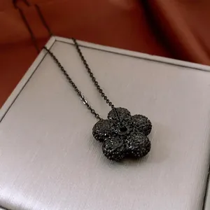 Elegant black floral pendant necklace with sparkling crystals on a sleek chain link