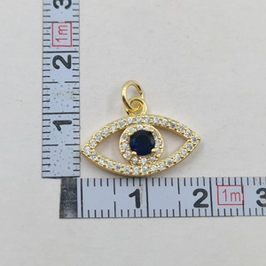 Detailed measurement showing evil eye pendant size of 1.5cm by 2cm on a ruler