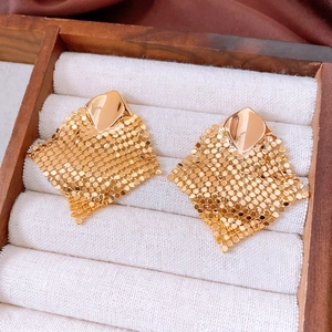 Detailed view of 18k gold plated rhombic mesh tassel earrings on a velvet jewelry box