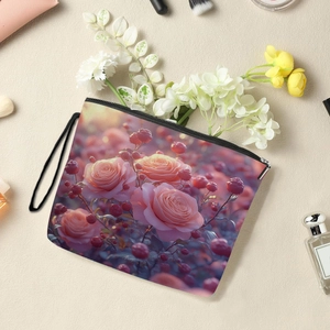 Floral makeup bag with pink roses, black zipper and wristlet on a textured background