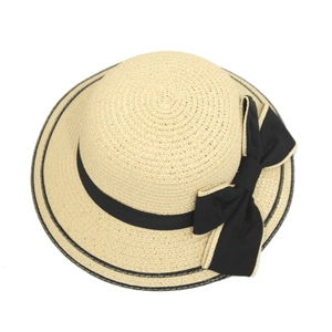 Close-up of beige woven straw sun hat with black bow ribbon and white edge details
