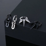 Detail of punk style stainless steel hoop earrings with spike and oval pendants