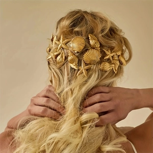 Elegant gold starfish and seashell hair pins on wavy blonde hair for a beach vacation style