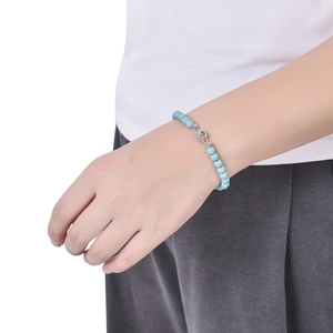 Close-up of light blue turquoise beaded bracelet with silver projection charm on wrist