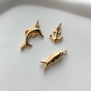 Polished gold stainless steel charms featuring dolphin, anchor, and striped fish details