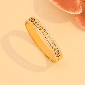 Detailed macro view of a gold chain-textured bracelet with sparkling pavé rhinestones