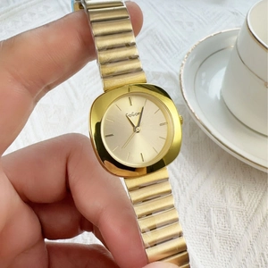 Elegant gold square dial ladies quartz watch with metallic stretch band on wrist