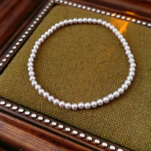 Close-up of elegant pinkish-white pearls on a vintage green fabric background