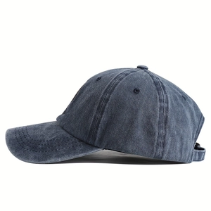 Detail of washed denim baseball cap featuring side stitching and adjustable metal buckle strap