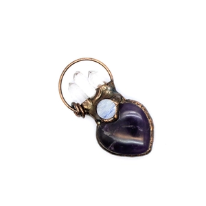 Macro view of handmade heart amethyst and quartz crystals wrapped in copper wire