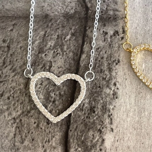 Detailed close-up of a 925 silver hollow heart pendant with sparkling pavé zircon stones