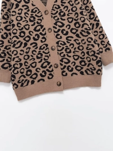 Detailed view of V-neck leopard print knit cardigan with buttons on white background