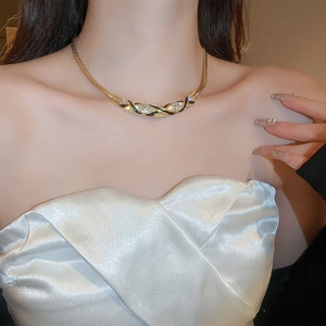 Detailed view of a gold braided choker with black enamel and sparkling rhinestones