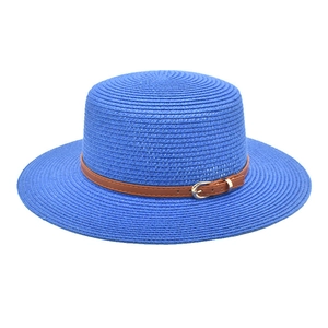 Detail of royal blue boater straw hat with fine weave and brown leather strap buckle