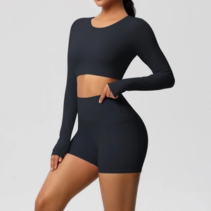 Detail van een zwarte sportset met zakshort en cropped shirt met lange mouwen