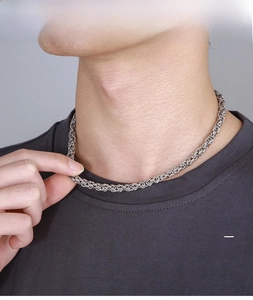 Close-up of men's silver Byzantine link chain necklace worn on neck with smooth metallic finish