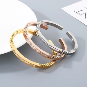 Detailed view of silver, gold, and rose gold stainless steel bangles with cubic zirconia