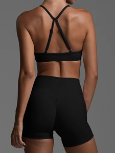 Detailansicht des Crossover-Rückendesigns des schwarzen Sport-BHs und der Yoga-Shorts