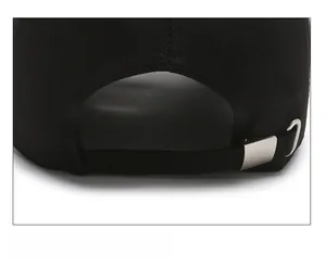 Close-up of black baseball cap rear showing adjustable fabric strap and metal buckle