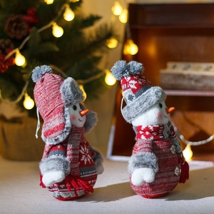Christmas snowman plush figures in red and gray knit outfits with festive background