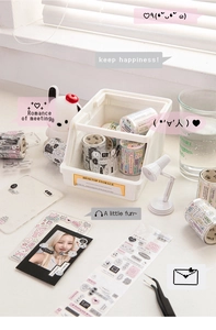 DIY scrapbooking set with patterned tapes and stickers in a desktop storage box