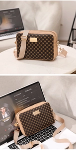 Close-up of vintage pattern crossbody bag with golden hardware on a laptop keyboard