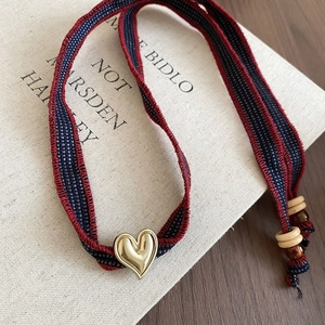 Detailed macro view of woven heart pendant on vintage book with rustic wood textures
