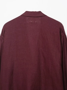 Close-up of the burgundy linen blazer collar and textured fabric shoulder details