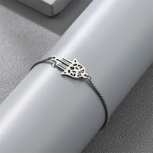 Detailed view of silver Hamsa Hand charm on a fine bead chain bracelet for men
