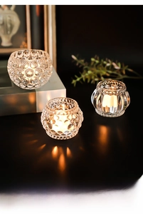 Detailed view of thick textured glass candle holders with elegant lighting effects
